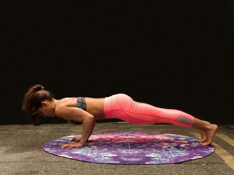 A woman in pink pants and top doing yoga.