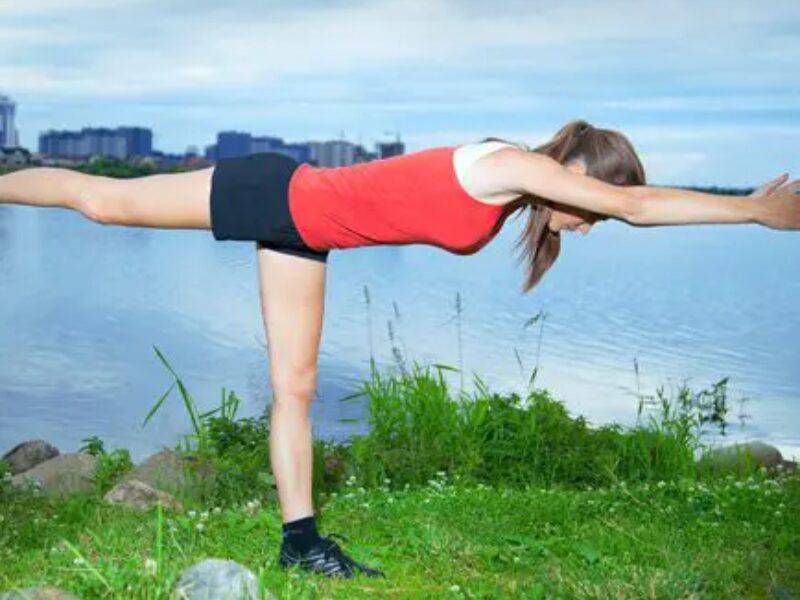 A woman is doing yoga on the grass