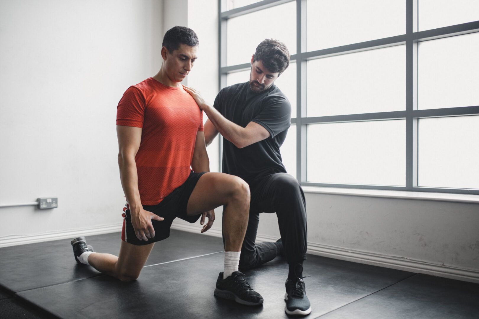 Two men are doing exercises in a gym.